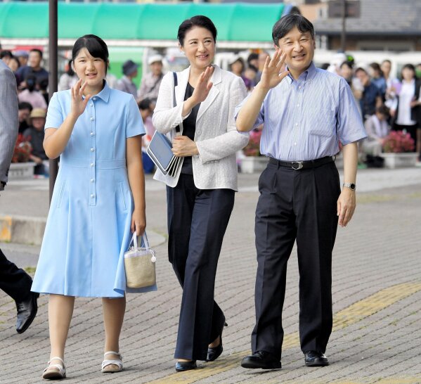 Japan's then Crown Prince Naruhito, then Crown Princess Masako, center, and Princess Aiko wave to well-wishers on their arrival at a station in Nasushiobara, Tochigi prefecture, Japan on Aug. 25, 2018. Japanese Emperor Naruhito, his wife, Empress Masako, and their daughter Aiko have canceled their annual trip to a summer resort, citing social distancing challenges amid the coronavirus pandemic. (Kyodo News via AP)