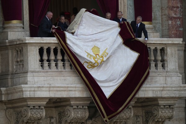 Vatican clerks prepare the central balcony of St Peter's Basilica ahead of the appearance Pope Leo XIV following his election, at the Vatican, Thursday, May 8, 2025. (AP Photo/Luca Bruno)