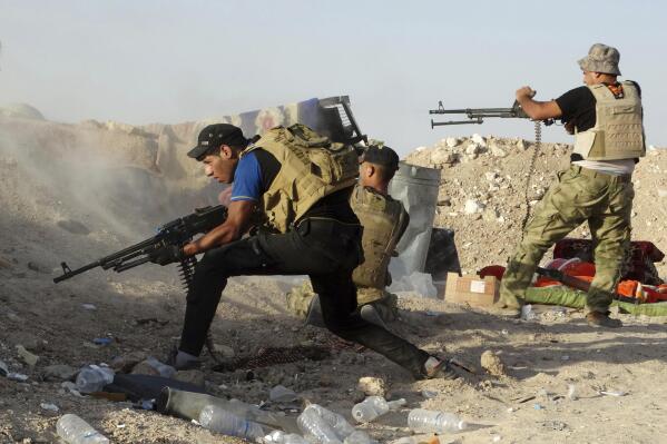 FILE - In this Monday, June 15, 2015, Iraqi security forces defend their positions against an Islamic State group attack in Husaybah, 8 kilometers (5 miles) east of Ramadi, Iraq. (AP Photo, File)