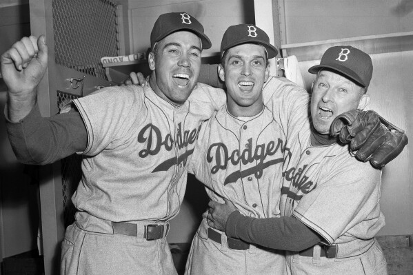 FILE - Brooklyn Dodgers pitcher Carl Erskine, center, celebrates with teammate Duke Snider, left, and manager Charley Dressen after beating the Yankees 6-5 in Game 5 of the World Series at Yankee Stadium in New York, Oct. 5, 1952. Carl Erskine, who pitched two no-hitters as a mainstay on the Brooklyn Dodgers and was a 20-game winner in 1953 when he struck out a then-record 14 in the World Series, died Tuesday, April 16, 2024, at Community Hospital Anderson in Anderson, Indiana, according to Michele Hockwalt, the hospital's marketing and communication manager. He was 97. (AP Photo)