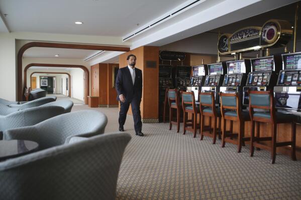 Hamza Mustafa, the CEO of Dubai’s Ports, Customs and Free Zone Corp.’s investment arm, passes slot machines that will remain turned off as gambling is illegal, aboard the Queen Elizabeth 2, moored off the Mideast city-state of Dubai, United Arab Emirates, Tuesday, April 17, 2018. Britain's famed luxury cruise ship finally will have a soft opening Wednesday as a floating luxury hotel nearly a decade after arriving here following her last ocean voyage. (AP Photo/Kamran Jebreili)
