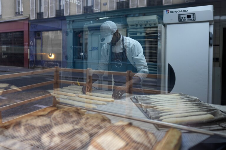 Baker Xavier Netry makes baguettes in the Utopie bakery Friday, April 26, 2024 in Paris. (AP Photo/Thibault Camus)