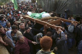 FILE - In this Nov. 15, 2018, file photo, mourners carry the body of Palestinian fisherman Nawaf Al-Attar, 20, who was shot and killed by Israeli troops on the beach near the border with Israel, during his funeral in Beit Lahiya, northern Gaza Strip. An Israeli soldier who shot and killed the Palestinian fisherman near the Gaza frontier in 2018 has been given 45 days of community service after an army investigation concluded he fired without authorization, the military said Thursday, June 18, 2020.(AP Photo/Adel Hana, File)