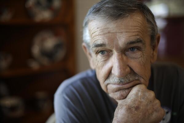 FILE - In this Aug. 7, 2019, photo, Doug Bledsoe sits in his home in Powell, Tenn. Bledsoe was called to work at Kingston Fossil Plant just days after the 2008 collapse of a six-story earthen dam released more than a billion gallons of coal ash sludge. Bledsoe drove a water truck there until 2014. In 2018, he was diagnosed with lung and brain cancer. He died two years later, leaving behind his wife of 38 years, Johnnie Bledsoe. (AP Photo/Mark Humphrey, File)