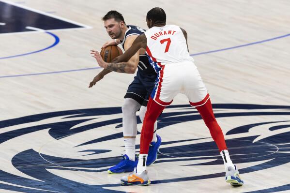 El esloveno Luka Doncic trata de avanzar con el balón ante Kevin Durant, de los Nets de Brooklyn en e encuentro del lune 7 de noviembre de 2022 (AP Foto/Brandon Wade)