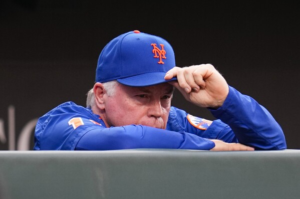 New York Mets manager Buck Showalter tips his hat as he is honored on the big screen prior to a baseball game between the Baltimore Orioles and the New York Mets, Friday, Aug. 4, 2023, in Baltimore. (AP Photo/Julio Cortez)