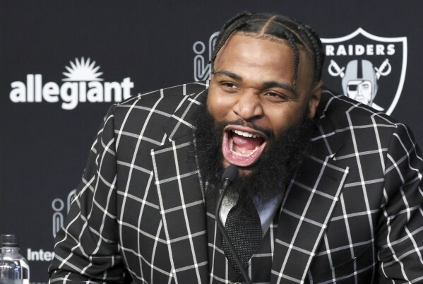 Las Vegas Raiders defensive tackle Christian Wilkins yells "Raiders!" at the start of an NFL football news conference, Thursday, March 14, 2024, in Henderson, Nev. (Steve Marcus/Las Vegas Sun via AP)