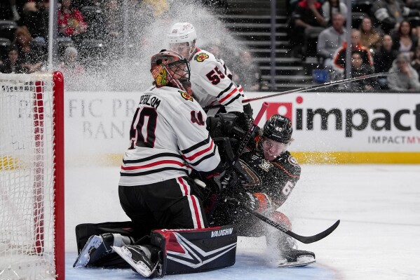 Anaheim Ducks defenseman Jackson LaCombe (60) collides with Chicago Blackhawks goaltender Arvid Soderblom (40) after a shot during the third period of an NHL hockey game Thursday, March 21, 2024, in Anaheim, Calif. (AP Photo/Ryan Sun)