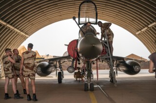 FILE - French Barkhane Air Force mechanics maintain a Mirage 2000 on the Niamey, Niger base, on June 5, 2021. Nigeriens are preparing for war against regional countries threatening to invade, three weeks after mutinous soldiers ousted the nation’s democratically elected president. Residents in the capital, Niamey, are calling for the mass recruitment of volunteers to assist the army in the face of a growing threat by the West African regional bloc, ECOWAS, which says it will use military force if the junta doesn’t reinstate the deposed President Mohamed Bazoum. (AP Photo/Jerome Delay, File)