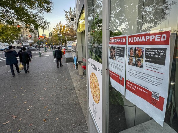 Posters of Israeli hostages being held by Hamas after the militant group's attack on Israel the month before, hang inside a window of the Jewish Children's Museum, Friday, Nov. 3, 2023, in the Brooklyn borough of New York. While posters of hostages were created to raise awareness and support, they've also angered others who are critical of Israel's actions and history in the conflict with Palestinians. (AP Photo/Bebeto Matthews)