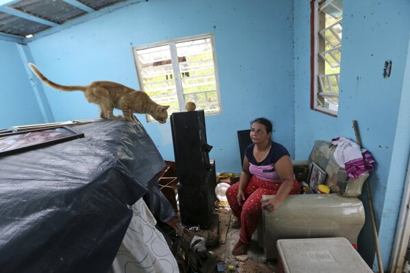 
              Maribel Valentin Espino sits in her hurricane-destroyed home in Montebello, Puerto Rico, Tuesday, Sept. 26, 2017. Five days after the Category 4 storm slammed into Puerto Rico, many of the more than 3.4 million U.S. citizens in the territory were still without adequate food, water and fuel. Flights off the island were infrequent, communications were spotty and roads were clogged with debris. Officials said electrical power may not be fully restored for more than a month. (AP Photo/Gerald Herbert)
            
