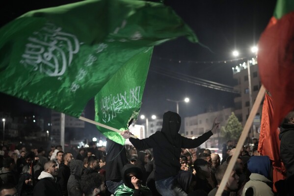 Palestinians celebrate a ceasefire agreement between Hamas and Israel in the West Bank city of Beitunia, on Sunday, Jan. 19, 2025. (AP Photo/Leo Correa)