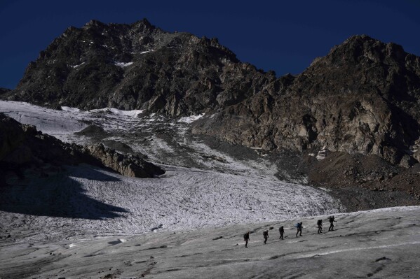 A group of hikers walk on the Jamtalferner Glacier near Galtuer, Austria, Wednesday, Sept. 6, 2023. (AP Photo/Matthias Schrader)