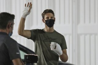 Haas driver Romain Grosjean of France waves Thursday, Dec. 3, 2020, at Bahrain International Circuit in Sakhir, Bahrain. Grosjean escaped with only minor burns when his Haas car exploded into a fireball after crashing on the first lap at last weekend's Bahrain GP. (AP Photo/Kamran Jebreili)