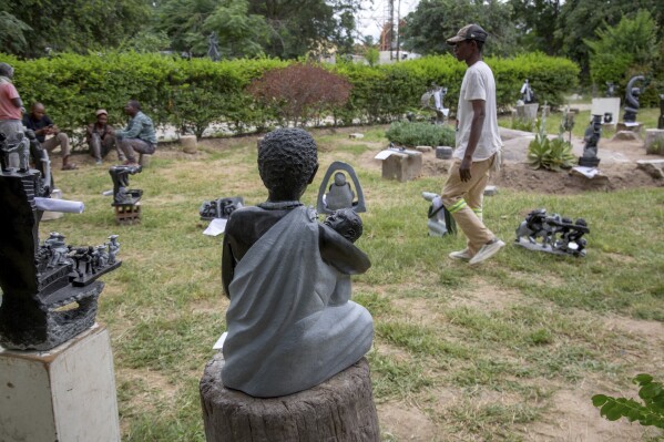 People walk past sculptures that will be part of an upcoming exhibition at Oxford University aiming to contextualize the legacy of British imperialist Cecil John Rhodes, at the Chitungwiza Arts Centre near Harare, Zimbabwe, Tuesday, March 4, 2025. (AP Photo/Aaron Ufumeli)
