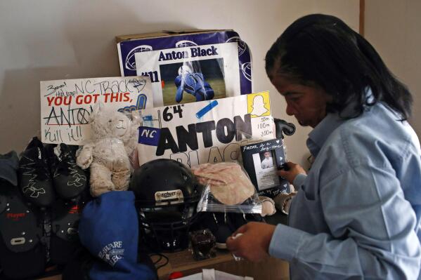 FILE- In this Jan. 28, 2019, file photo, Jennell Black, mother of Anton Black, looks at a collection of her son's belongings at her home in Greensboro, Md. Relatives of Anton Black, a 19-year-old Black man who died during a struggle with police officers on Maryland's Eastern Shore, have reached a $5 million partial settlement of their wrongful death lawsuit, an agreement that also requires improvements in police training and policies, family attorneys announced Monday, Aug. 8, 2022. (AP Photo/Patrick Semansky, File)