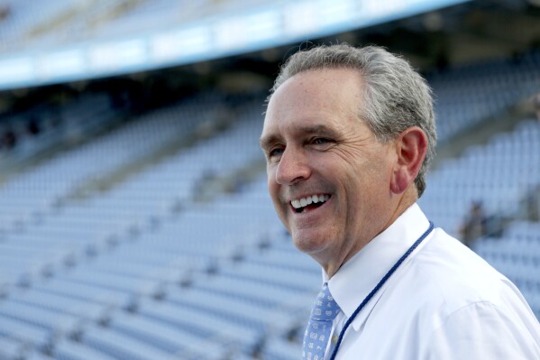 FILE - In this Sept. 7, 2019, file photo, North Carolina athletic director Bubba Cunningham smiles as he talks with stadium workers before the start of of an NCAA college football game against Miami in Chapel Hill, N.C. Interim chancellor Lee Roberts publicly backed Cunningham after the school’s board of trustees approved an audit of his department due to financial concerns growing amid the volatile state of college athletics. (AP Photo/Chris Seward, File)