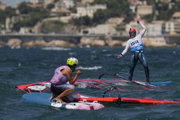 Marta Maggetti of Italy, left, looks to Sharon Kantor of Israel as she celebrates her women's iQFOiL windsurfing silver medal win during the 2024 Summer Olympics, Saturday, Aug. 3, 2024, in Marseille, France. Maggetti won gold. (AP Photo/Carolyn Kaster)