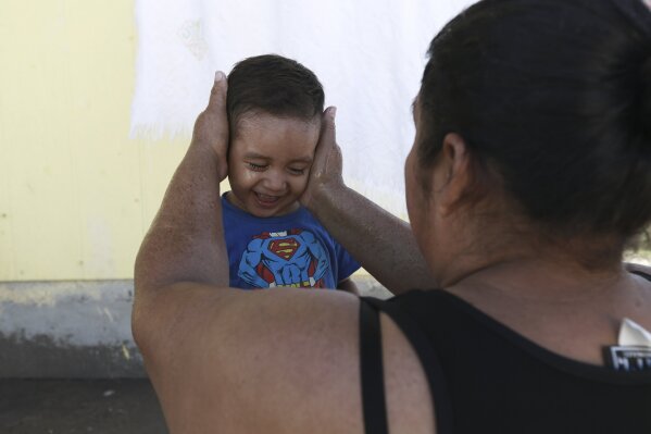 A migrant mother washes her son's face at the Pan de Vida shelter where they are living in Ciudad Juarez, Mexico, while waiting for a chance to request asylum in the United States, Thursday, Sept. 12, 2019. Mexican Foreign Secretary Marcelo Ebrard said Thursday that Mexico's government doesn't agree with an "astonishing" U.S. Supreme Court order that would block migrants from countries other than Mexico and Canada from applying for asylum at U.S. borders. (AP Photo/Christian Chavez)