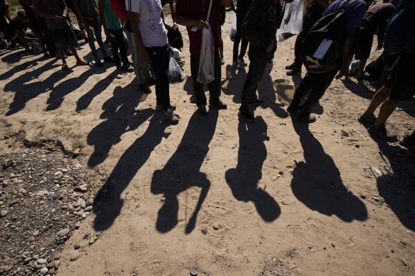 FILE - Migrants wait to be processed by the U.S. Customs and Border Patrol after they crossed the Rio Grande and entered the U.S. from Mexico, Oct. 19, 2023, in Eagle Pass, Texas. The U.S. 5th Circuit Court of Appeals on Thursday, Feb. 29, 2024, allowed a Texas law to proceed that lets state police arrest migrants and local judges to order them to leave, paving the way to a U.S. Supreme Court battle. The law, which was initially set to take effect Tuesday, March 5, will be able to take effect Saturday, March 9. (AP Photo/Eric Gay, File)