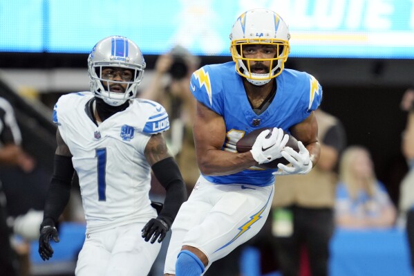 Los Angeles Chargers wide receiver Jalen Guyton (15) makes a touchdown catch in front of Detroit Lions cornerback Cameron Sutton (1) during the second half an NFL football game Sunday, Nov. 12, 2023, in Inglewood, Calif. (AP Photo/Ashley Landis)