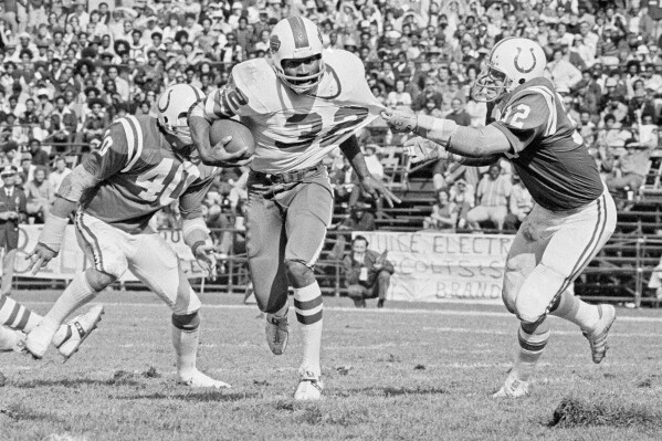 FILE - Buffalo Bills running back O.J. Simpson (32) has his jersey pulled by Baltimore Colts linebacker Mike Curtis, during the second quarter of an NFL football game in Baltimore, Md., Oct. 12, 1975. Simpson, the decorated football superstar and Hollywood actor who was acquitted of charges he killed his former wife and her friend but later found liable in a separate civil trial, died Wednesday, April 11, 2024, of prostate cancer. He was 76. (AP Photo/File)