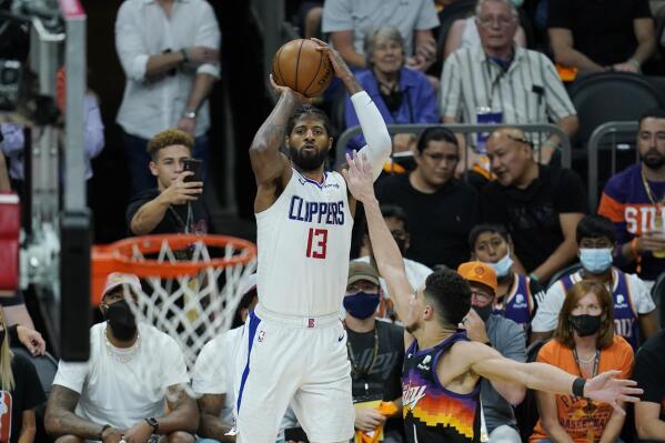 FILE - Los Angeles Clippers guard Paul George (13) shoots a three-point basket over Phoenix Suns guard Devin Booker, right, during the second half of Game 1 of the NBA basketball Western Conference finals in Phoenix, in this Sunday, June 20, 2021, file photo. No Kawhi Leonard means even more Paul George for the Clippers. With Leonard out while recovering from knee surgery, George becomes the primary scorer for a team looking to make a deeper run in the playoffs. (AP Photo/Ross D. Franklin, File)