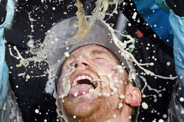 Tyler Reddick gets doused by his crew as he celebrates in Victory Lane after winning a NASCAR Cup Series auto race at Kansas Speedway in Kansas City, Kan., Sunday, Sept. 10, 2023. (AP Photo/Colin E. Braley)