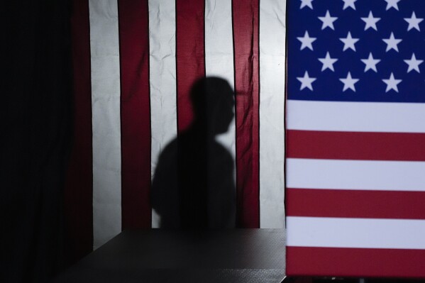 A worker walks back stage after Republican presidential candidate Florida Gov. Ron DeSantis finished speaking to supporters during a caucus night party, Monday, Jan. 15, 2024, in West Des Moines, Iowa. (AP Photo/Charlie Neibergall)