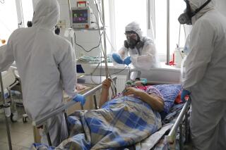 Medical staff members wearing special suits to protect against coronavirus discuss about treating a patient with coronavirus at an ICU of the Clinical hospital in Volgograd, Russia, Monday, Jan. 31, 2022. Russia's state coronavirus task force reported a total of 11.8 million confirmed cases in the pandemic and 331,349 deaths — by far the highest death toll in Europe. However, reports by Russia's state statistics service Rosstat, which uses wider criteria for counting virus-linked deaths, revealed much higher numbers. (AP Photo/Alexandr Kulikov)