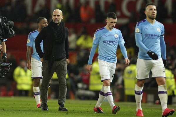 Manchester City's head coach Pep Guardiola, second from left, and team players leave the pitch after the English Premier League soccer match between Manchester United and Manchester City at Old Trafford in Manchester, England, Sunday, March 8, 2020. Manchester United won 2-0. (AP Photo/Dave Thompson)