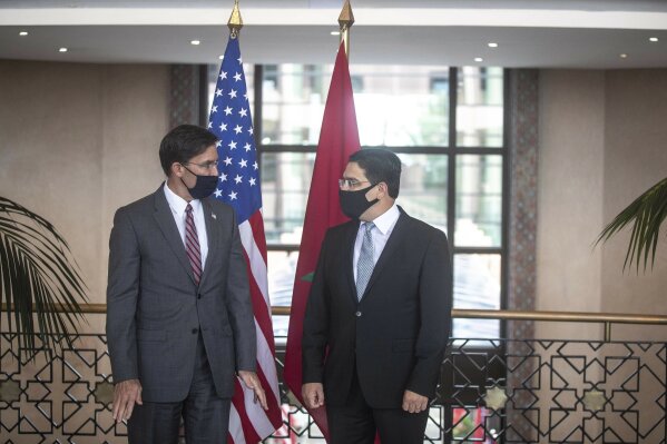 US Secretary of Defense Mark Esper, left, is received by Moroccan Foreign Minister Nasser Bourita, right, in Rabat, Morocco, Friday, Oct. 2, 2020. The visit is part of U.S. Defense Secretary Mark Esper's North Africa tour and is his first visit to Africa as defense secretary. (AP Photo/Mosa'ab Elshamy)
