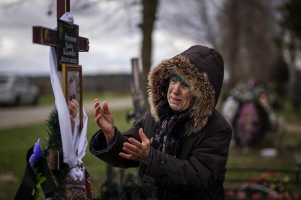 Valentyna Nechyporenko, 77, mourns at the grave of her 47-year-old son Ruslan, during his funeral at the cemetery in Bucha, on the outskirts of Kyiv, Monday, April 18, 2022. Ruslan was killed by Russian army on March 17 while delivering humanitarian aid to his neighbours in the streets of Bucha. (AP Photo/Emilio Morenatti)