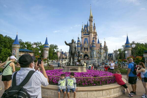FILE - People visit Magic Kingdom Park at Walt Disney World Resort in Lake Buena Vista, Florida, on April 18, 2022. The Walt Disney Co. announced Tuesday, Jan. 10, 2023, that they would be making several changes at its domestic theme parks in order to improve public perception of its business. (AP Photo/Ted Shaffrey, File)