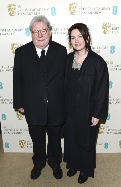FILE - Director Alan Parker and his wife, Lisa arrive for the BAFTA Film Awards in London on Feb. 10, 2013. Parker, whose movies included “Bugsy Malone,” “Midnight Express” and “Evita,” has died at the age of 76. A statement from the director’s family says Parker died Friday in London after a long illness. (Photo by Jon Furniss/Invision/AP, File)