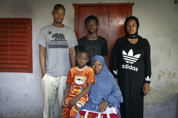 The mother and siblings of the late Ousmane Sylla gather for a photograph at their house after his funeral in Matoto Bonagui, a suburb in Conakry, Guinea, Tuesday, April 9, 2024. (AP Photo/Misper Apawu)