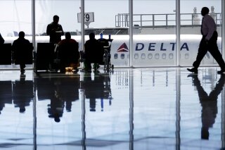 
              FILE - In this Thursday, Oct. 13, 2016, file photo, a Delta Air Lines jet sits at a gate at Hartsfield-Jackson Atlanta International Airport, in Atlanta. Delta is giving airport employees permission to offer passengers up to almost $10,000 in compensation to give up their seats on overbooked flights. Delta's move comes as United Airlines struggles to recover from images of a passenger's forced removal from a sold-out flight. (AP Photo/David Goldman, File)
            