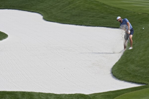 Scottie Scheffler hits from the bunker along the second fairway during a practice round for The Players Championship golf tournament Wednesday, March 13, 2024, in Ponte Vedra Beach, Fla. (AP Photo/Chris O'Meara)
