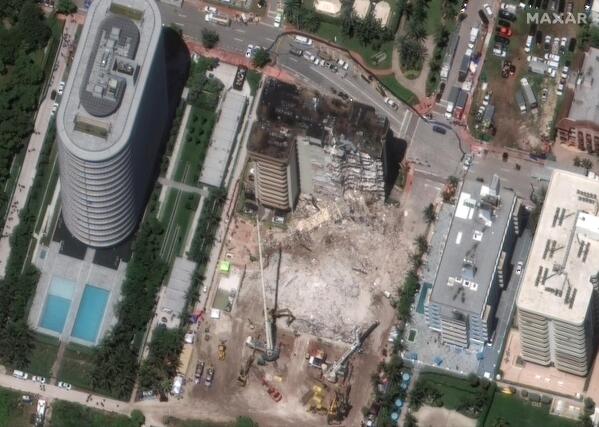 In this satellite image provided by Maxar Technologies heavy-lift cranes are used to aid in the search and recovery operation at the partially collapsed Champlain Towers South condo building on Saturday, July 3, 2021, in Surfside, Fla. (Maxar Technologies via AP)