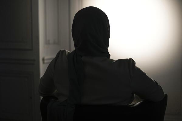 The sister, who refused to show and identify, of a woman imprisoned in Turkey is silhouetted during an interview with The Associated Press in Paris, Wednesday, Feb. 16, 2022. Shatz and a team of European lawyers filed a case against Greece at the European Court of Human Rights on behalf of a 32-year-old French woman who accuses the Hellenic country of forcibly pushing her back across the border from Greece to Turkey, where she claims she is a victim of political persecution. The woman, who is also a Turkish national, was subsequently arrested and jailed. (AP Photo/Michel Euler)
