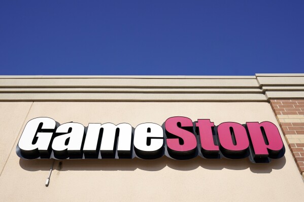 FILE - A GameStop sign is displayed above a store in Urbandale, Iowa, on Jan. 28, 2021. GameStop managed to narrow its losses in the first quarter, but the video game retailer's revenue fell as sales weakened for hardware and accessories, software and collectibles. The results were released shortly after the man at the center of the pandemic meme stock craze, who is known as “Roaring Kitty” on social media platforms YouTube and X, disclosed that he'll be hosting a YouTube livestream on Friday June 7, 2024. (AP Photo/Charlie Neibergall, File)