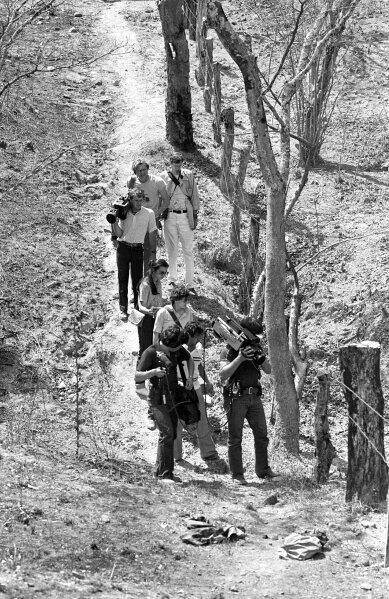 
              In this March 18, 1982 photo, television cameramen photograph blood-soaked, bullet-ridden clothes believed to belong to four Dutch journalists killed in a wooded area near this village in the province of Chalatenango, in El Salvador. Jan Kuiper, Koos Koster, Hans ter Laag and Joop Willemsen were killed in 1982 while on assignment for IKON, a Dutch public TV broadcaster. (AP Photo/P.W. Hamilton)
            