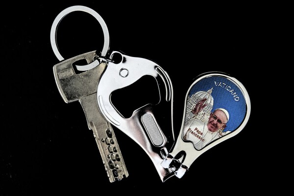 A bottle opener, nail clipper, and key chain with a picture of Pope Francis in Rome, Thursday, May 1, 2025. (AP Photo/Bernat Armangue)