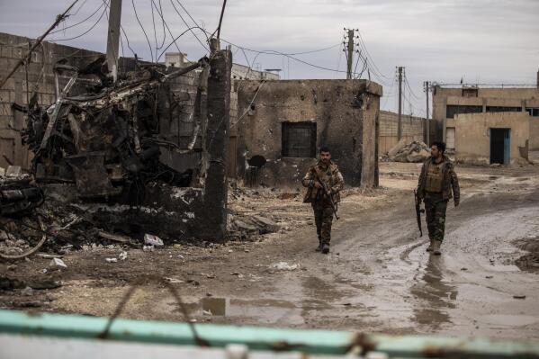Syrian Democratic soldiers keep watch by the prison that was attacked by the Islamic Stete militants in Hassakeh, Syria, Tuesday, Feb. 8, 2022. The Jan. 20 attack on the prison in northeast Syria was the biggest IS operation in years, and it took the U.S.-backed Syrian Kurdish forces 10 days to defeat it. (AP Photo/Baderkhan Ahmad)