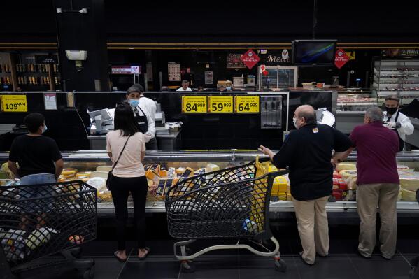People shop at a supermarket in Beirut, Lebanon, Monday, July 15, 2022. In Lebanon, where endemic corruption and political stalemate has crippled the economy, the World Food Program is increasingly providing people with cash assistance to purchase food, particularly after the devastating 2020 port blast that destroyed massive grain silos. (AP Photo/Bilal Hussein)