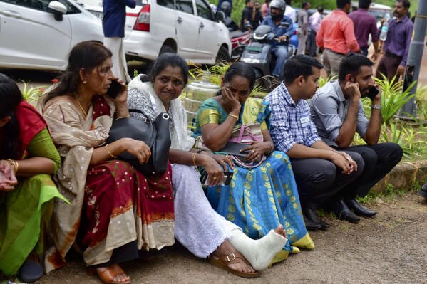 Jehovah's Witness faithful and others wait outside the Zamra International Convention Center after an explosive device blew up during their prayer session in Kalamassery, a town in Kochi, southern Kerala state, India, Sunday, Oct.29, 2023. At least one person died and 36 others were injured in the explosion, authorities said. (AP Photo)