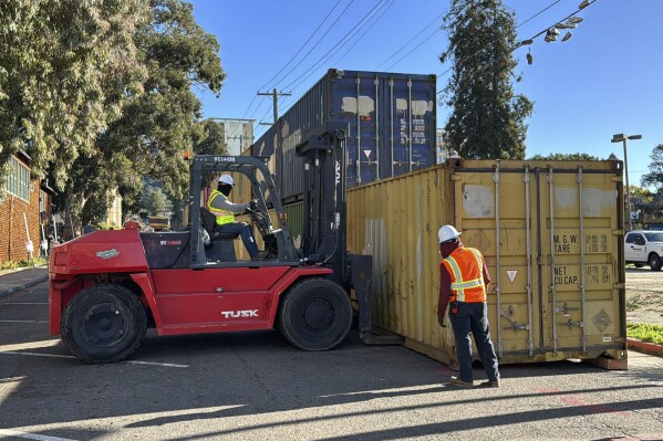 Shipping containers are placed around People's Park in Berkeley, Calif., Thursday, Jan. 4, 2024. Police officers in riot gear removed activists and crews began placing double-stacked shipping containers to wall off the historic park as the University of California, Berkeley waits for a court ruling it hopes will allow it to build much-needed student housing. (AP Photo/Terry Chea)