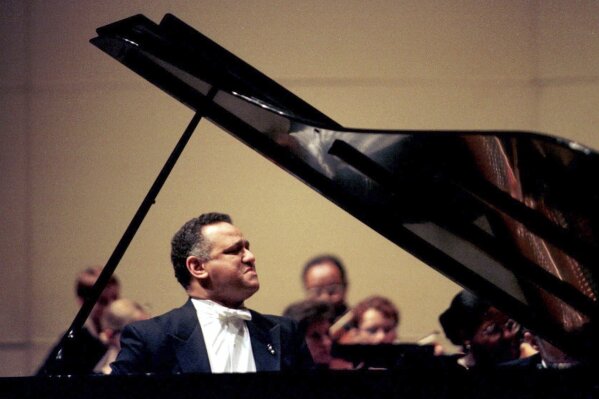 FILE - Pianist Andre Watts performs with the Kalamazoo (Mich.) Symphony Orchestra during the opening concert of the Irving S. Gilmore International Keyboard Festival at Miller Auditorium on the Kalamazoo (Mich.) campus of Western Michigan University, on April 29, 2000. Watts died Wednesday, July 12, 2023 in Bloomington, Ind. He was 77.(Henrik Edsenius/Kalamazoo Gazette via AP)