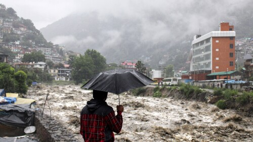 A man looks at a swollen River Beas following heavy rains in Kullu, Himachal Pradesh, India, Sunday, July 9, 2023. According to local reports heavy rain fall has triggered landslides, damaged houses and caused loss of lives. (AP Photo/ Aqil Khan)