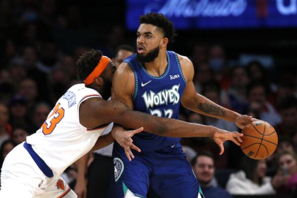 New York Knicks center Mitchell Robinson defend against Minnesota Timberwolves center Karl-Anthony Towns (32) during the second half of an NBA basketball game, Tuesday, Jan. 18, 2022 in New York. The Minnesota Timberwolves won 112-110. (AP Photo/Noah K. Murray)